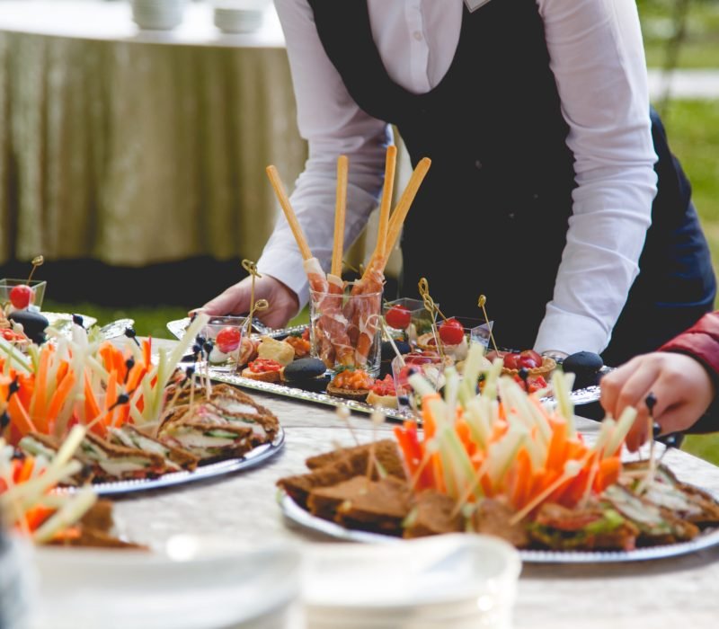 The waiter puts snacks on a buffet.