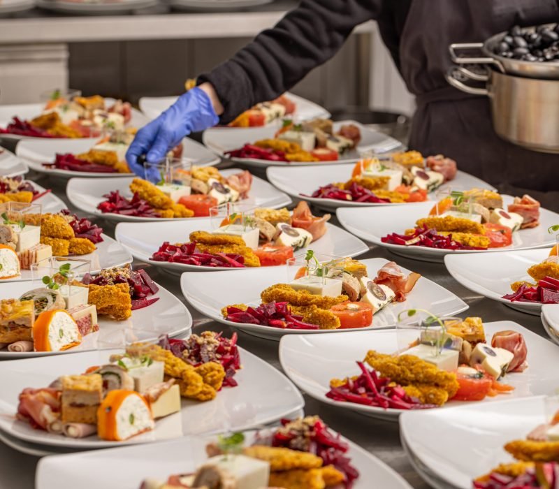 A chef arranging a plate of appetisers for wedding table